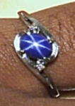 A "star sapphire" ring with two diamonds on a silver band