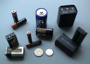 Various batteries(clockwise from bottom left): two 9-volt, two "AA," one "D," a cordless phone battery, a camcorder battery, a 2-meter handheld ham radio battery, and a button battery, one "C" and two "AAA," plus a U.S. quarter, for scale