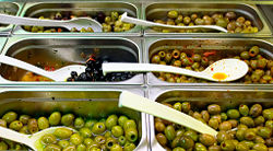 Some of the different varieties of marinated olives (black and green) sold by farmers and in shops