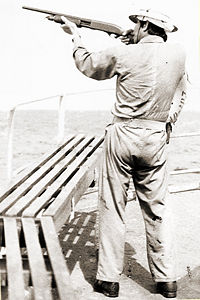 A U.S. merchant seaman takes aim during training to repel pirates in the Strait of Malacca, 1984.