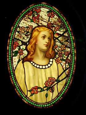 Girl with Cherry Blossoms illustrates many types of glass employed by Tiffany including elaborate polychrome painting of the face, drapery glass for the dress, opalescent glass for the blossoms, streaky glass in the border, fracture-streamer glass in the background, and what may be iridescent glass in the beads.
