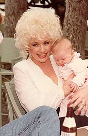 Parton, in Honolulu, holds a fan's baby in 1983
