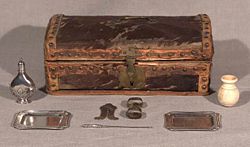 Family circumcision set and case, c. eighteenth century wooden box covered in cow hide with silver implements: Silver trays, clip, pointer, silver flask, spice vessel.