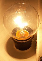An incandescent light bulb and its glowing filament.