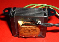 Laminated core transformer showing edge of laminations at top of unit.