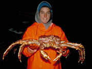 Alaskan fisherwoman holding a Red King Crab.