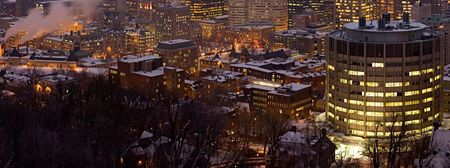 McGill's downtown campus at night viewed from Mount Royal. The circular building in the foreground is the McIntyre Medical Sciences Building.
