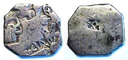 Silver punch mark coin of the Mauryan empire, with symbols of wheel and elephant. Third century B.C.E.