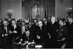 Lyndon B. Johnson signs the U.S. Civil Rights Act of 1964.