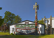 A Kwakwaka'wakw totem pole and traditional "big house" in Victoria, BC.