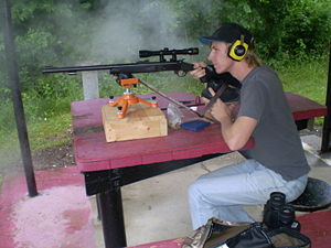 Firing a present day muzzle loading rifle at the bench rest. Note the white smoke from the firing.