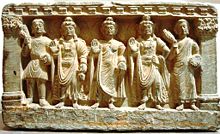 An early Mahayana Buddhist triad. From left to right, a Kushan devotee, the Bodhisattva Maitreya, the Buddha, the Bodhisattva Avalokitesvara, and a Buddhist monk. 2nd-3rd century, Gandhara.