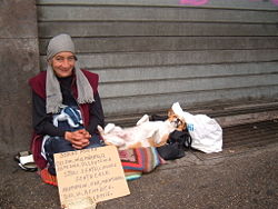A homeless Gypsy woman with her dog in a street of Rome