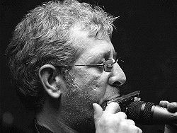 A man uses a microphone to change the sound of a harmonica.