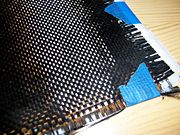 A cloth of woven carbon fiber filaments, a common element in composite materials