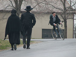 Amish couple and "English" youth. Most Amish young people remain in the church, but some choose to enter the "outside world."