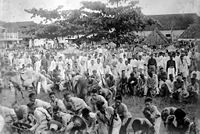 A group of Filipino combatants are photographed just as they lay down their weapons prior to their surrender.