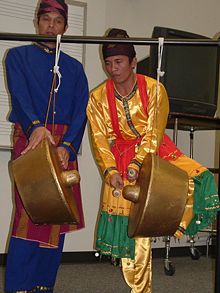 An agung contestant performing on the agung using two balus.