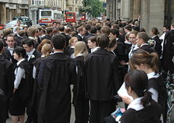 Students in subfusc outside Examination Schools. Note variety of gowns such as the Commoners' gown and the Graduate Student gown.