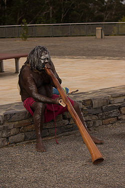 An aboriginal Australian plays a didgeridoo.