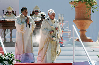 A Roman Catholic deacon (left) assists Pope Benedict XVI in Brazil.