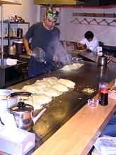 A man prepares okonomiyaki in a restaurant in Hiroshima