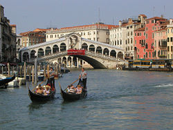 Gondola on Grand Canal beside Rialto Bridge.