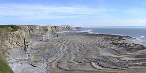Wave-cut platform caused by erosion of cliffs by the sea, at Southerndown in South Wales.