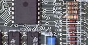 Part of a 1983 Sinclair ZX Spectrum computer board; populated PCB, showing conductive traces, through-hole paths onto the other surface, with some mounted electrical components