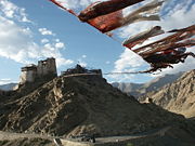 Prayer flags connect the two peaks of the peak of victory over Leh, Ladakh, India. On the other peak the Namgyal Tsemo Gompa can be seen