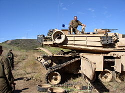 Sections of the side-skirt are swung aside on this M1 Abrams tank to expose the track so that a road wheel can be replaced.