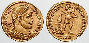 Julian solidus, c. 361. The reverse depicts an armed Roman soldier bearing a military standard in one hand and subduing a captive with the other, a reference to the military strength of the Roman Empire.