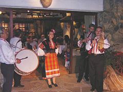 An orchestra in a Bulgarian mehana, with, from left to right, musicians playing the tapan, accordion, kaval and gadulka