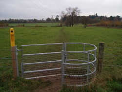 "Kissing gate" with yellow footpath markings.