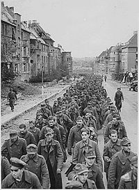 "The endless procession of German prisoners captured with the fall of Aachen marching through the ruined city streets to captivity." 10/1944