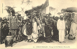 King Makoko of Téké (carried on chair) in procession to Brazzaville with French colonials, c. 1905.