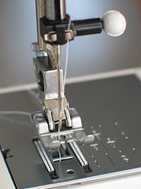 Needle plate, foot and transporter of a sewing machine