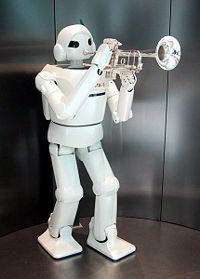A humanoid robot manufactured by Toyota appears to be playing a trumpet.