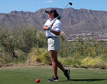 A golfer completes her follow-through.