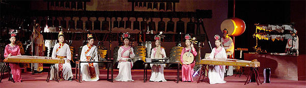 Replica instruments of ancient originals are played at the Hubei Provincial Museum. A spectacular replica set of bronze concert bells is in the background and a set of stone chimes is to the right