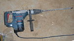 A large drill used in construction for drilling out holes needed for the electrical wiring.