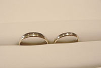 A set of wedding rings yellow and white gold with diamond stone in a presentation case.
