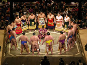 Sumo wrestlers gather in a circle around the Gyoji (Referee) in a pre-fight ceremony.