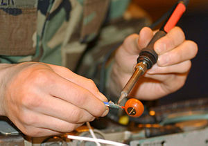 Use of a soldering iron to desolder a contact.