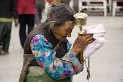 A Tibetan woman in Lhasa with traditional prayer wheel.