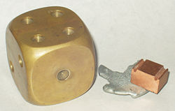 A decorative brass paperweight (left), alongside samples of zinc and copper.