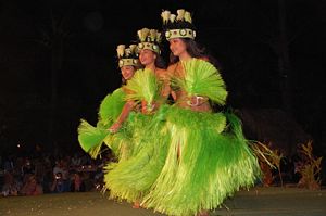 Contemporary hula. A performance of a contemporary hula with elaborate costumes and headgear.