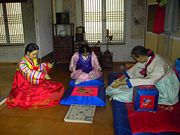 A game of yut played by family wearing hanbok