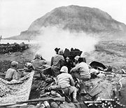 U.S. 37 mm gun fires against Japanese cave positions in north face of volcano