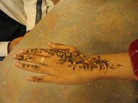 Henna is applied on women's hands at a Diwali Mela.